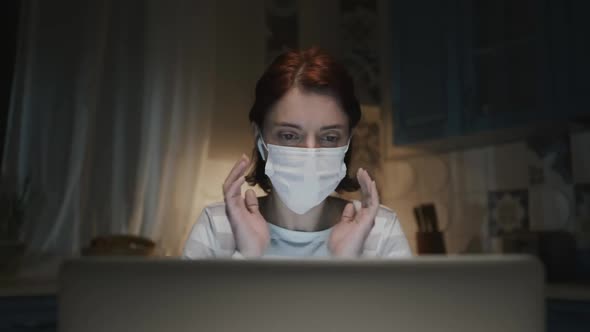 Young Girl In The Kitchen With Laptop. Young Woman Working Remotely At Home Because Of Pandemic