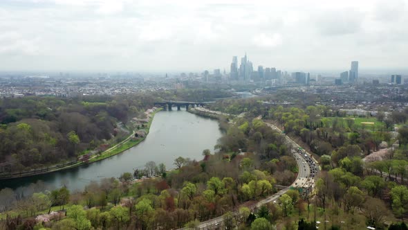 Aerial drone pan left of Philadelphia city skyline from above the Schuylkill River and highway traff