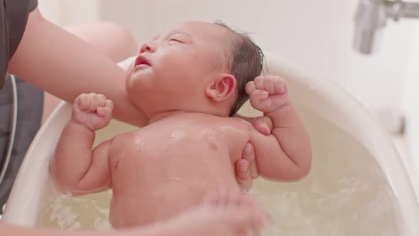 Calm of asian newborn baby bathing in bathtub