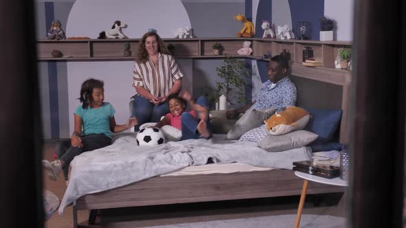Happy American Family Playing Ball in Bedroom