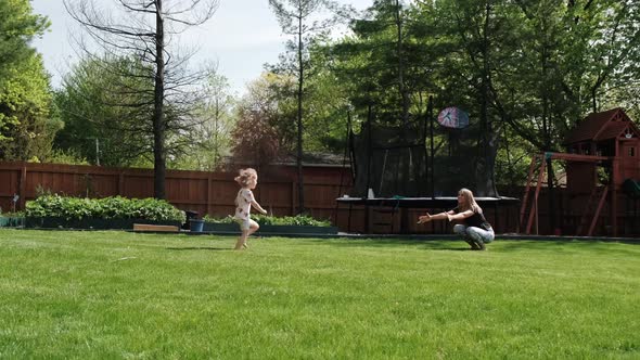 The Little Daughter Runs to Her Mother and Then They Spin Around Together in the Backyard