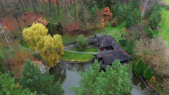 Rest of tourists in autumn forest. Resting building with pond in beautiful forest area
