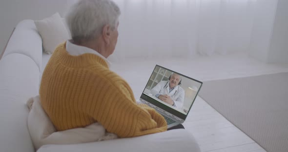 Old Man Is Watching Tv Programme About Health By Laptop, Professional Doctor Is Talking About