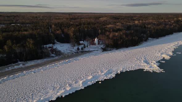 4k drone video of 40 Mile Point Lighthouse in Presque Isle County in Michigan during the winter.