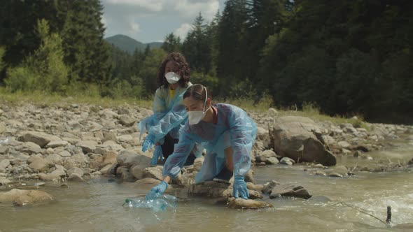 Environmentally Aware Pretty Multiracial Women Volunteers Picking Up Plastic Waste From Mountain