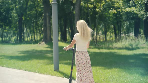 Woman Ride On Electric Scooter Mobility.E-Scooter Rider Rent Personal Eco Transport.