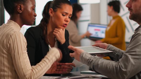 Close Up of Diverse Business Team Checking Graphs From Tablet Making New Strategy