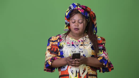 Overweight Beautiful African Woman Wearing Traditional Clothing Against Green Background