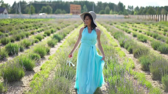 Wide Shot Portrait of Smiling Happy Elegant Woman in Blue Dress and Straw Hat Walking with Highheels