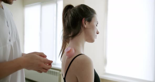 The Doctor is Treating a Woman with Suckers Cups on Her Back in a Clinic