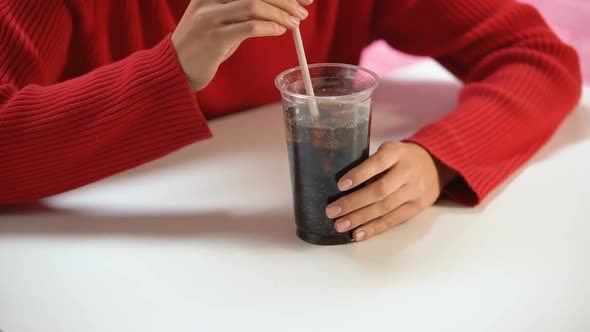 Female Customer Tasting Soft Drink From Plastic Glass Through Straw, Refreshment