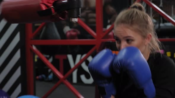 A Woman Training in a Gym She Practices Punches on a Rotating Boxing Simulator