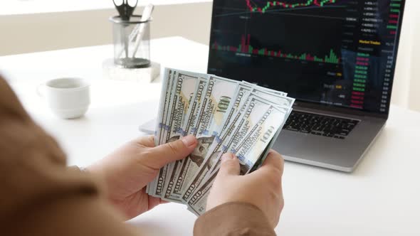 counting money dollars  laptop with stock market