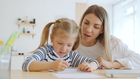 Mother and Little 6 Year Old Daughter Study Writing Letters at Home Mom Helps