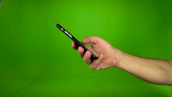 Male Hand Dials on the Phone Numbers. Green Screen. Side View