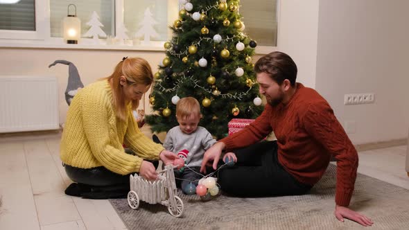 Happy Family Having Fun and Playing Together Near Christmas Tree