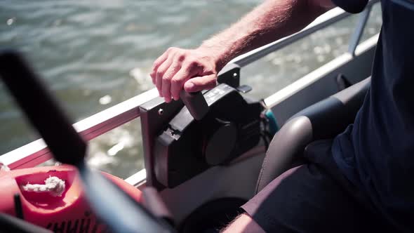 Man Adjusting Power Controls On Powerful Boat