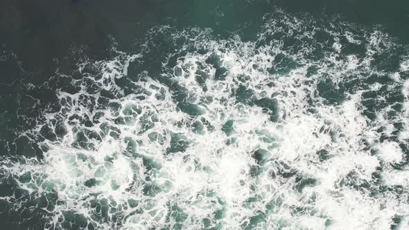 Aerial top view of rocks in the sea - Aerial video of majestic waves splashin