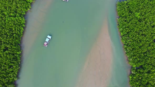 Aerial view of a Thai traditional longtail boat sailing in Phang Nga Bay among the fertile mangrove