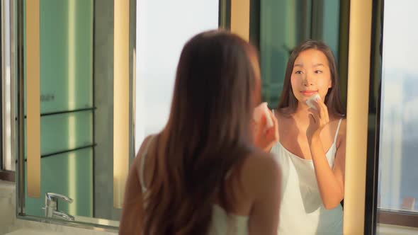 Young asian woman check her face on mirror