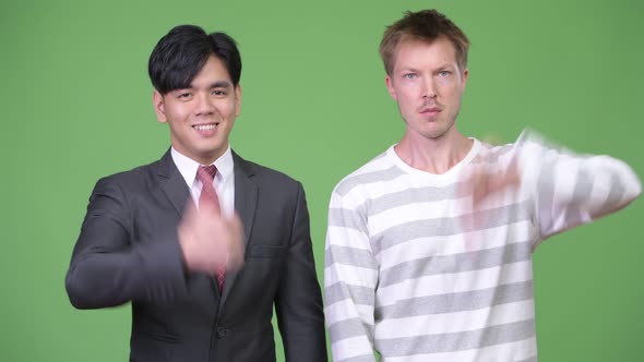 Young Handsome Asian Businessman and Young Scandinavian Businessman Working Together