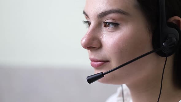 Close-up face of a girl who speaks with a client using a headset