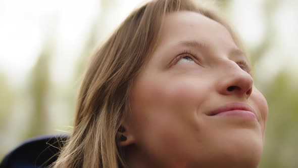 Beautiful Young Caucasian Woman Enjoying Fresh Air and Sun Rays in the Nature. Close Up Shot. Happy