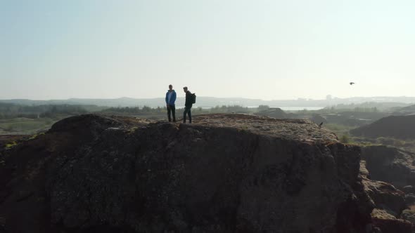 Drone View of Two Men Standing Over Cliff Looking Panorama in Iceland