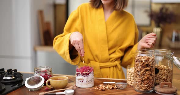 Woman Making Cereal Breakfast on the Kitchen at Home