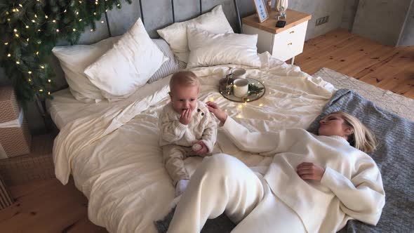 Mother's Christmas Mood with Her Child, Near the New Year Tree. Winter Holidays.