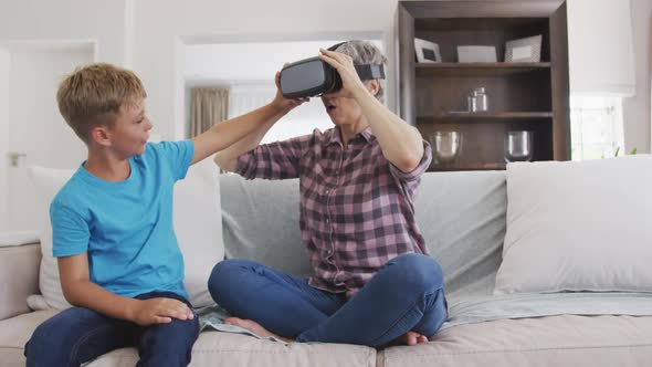 Senior woman wearing a Virtual Reality headset with her grandson