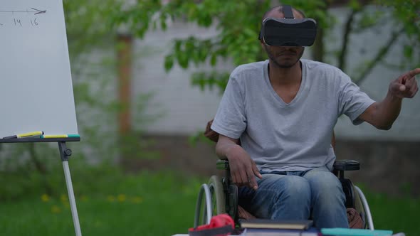 Front View Portrait of Serious Focused Disabled Male Designer in VR Headset Moving Hands Using