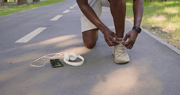 Close Up of African American Sportsman Fixing His Sneakers