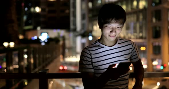 Young man use of mobile phone in the city 