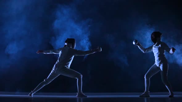 Two Female Athletes Train on Foil at Fencing Tournament