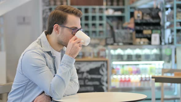 Relaxed Man Drinking Coffee in Cafe