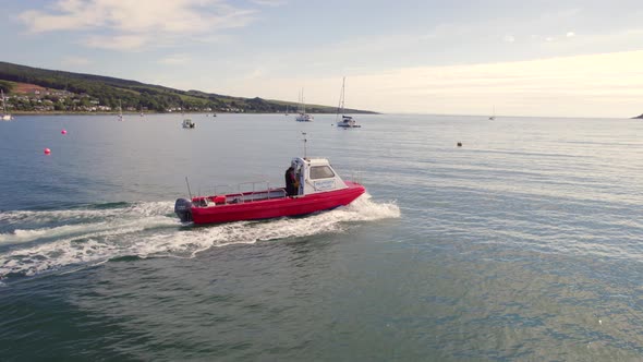 A Small Passenger Ferry at Sea Motoring Alongside an Island