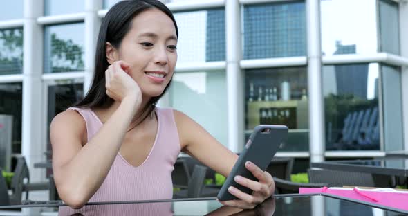 Woman Using Cellphone in Outdoor Cafe