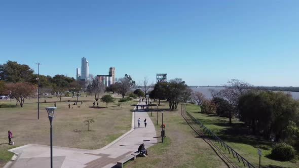 drone flight over a paved road in the park at the shores or banks of parana river in rosario where p