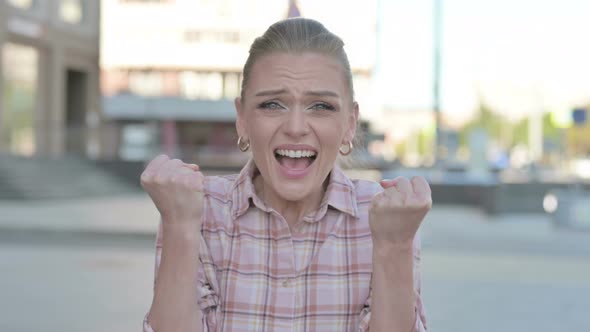 Portrait of Excited Young Woman Celebrating Success Outdoor