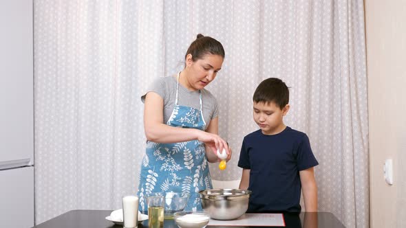 Woman Teaches Boy to Cook in the Kitchen