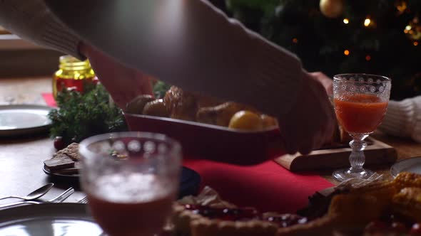 Closeup Tracking Shot of Young Man Putting Dish with Baked Hot Turkey on Dinner Table Served for