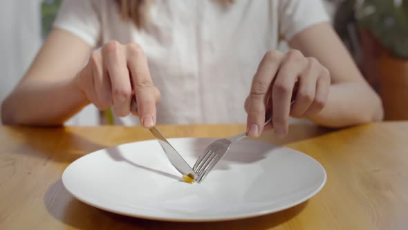 Close Up of Young Man Eating One Pea with Fork and Knife