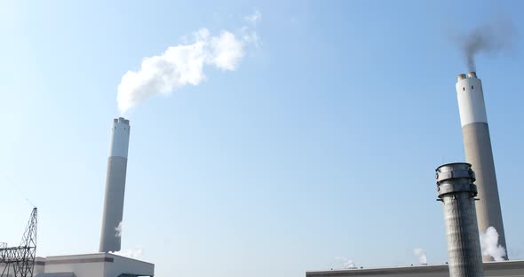 Air pollution by smoke coming out of the factory chimney