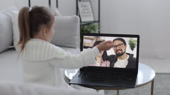 Young Girl Sitting and Relaxing on Sofa at Home and Talking on Video Call with Smiling Mother