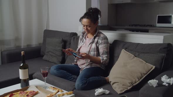 Depressed Woman with Tear Stained Face Looking at Photos Indoors