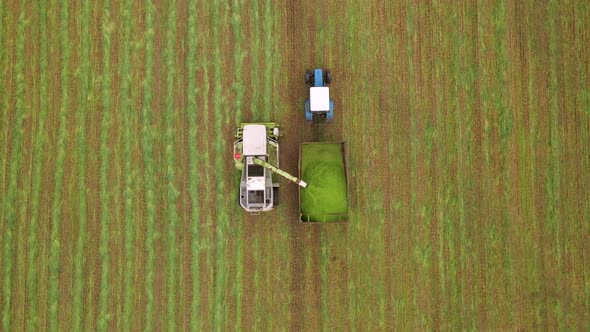 Aerial Shot of Modern Harvester Loading Off Barley on Tractor Trailers