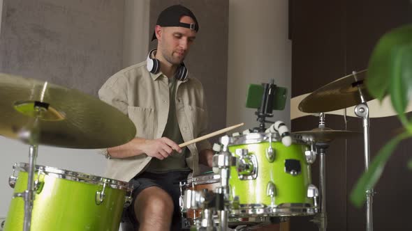 Man Records Drum Lesson on Phone and Shows Playing Technique