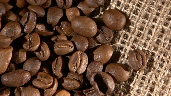 Handful of Brown, Roasted Coffee Beans on Burlap Sacking, Background, Close Up, Rotation