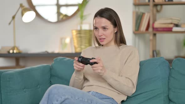 Young Woman Playing Video Game on Sofa